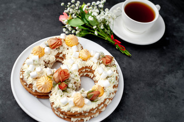 tea and cake in the form of 8 is decorated with flowers, cream cheese, marshmallows, Bizet on a stone background. romantic delicious breakfast on International Women's Day March 8