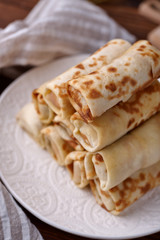 Russian pancakes with filling, lying on a plate with a slide