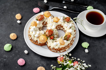 tea and cake in the form of 8 is decorated with flowers, cream cheese, marshmallows, Bizet on a...