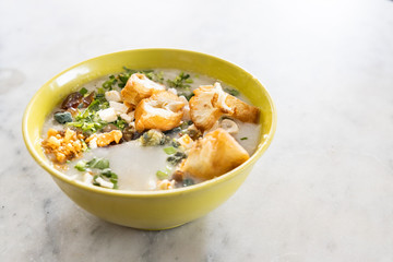 Delicious traditional Chinese congee porridge with youtiao, ginger, pork, scallion