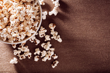 White bowl filled with popcorn spilled over the table