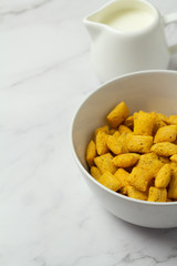 cornflakes in bowl on wooden table