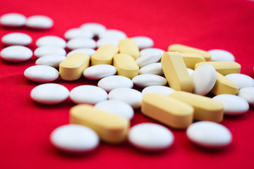  white and yellow pills on a red background