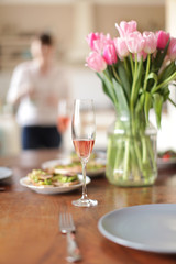 romantic dinner table setting with pink wine in a glass