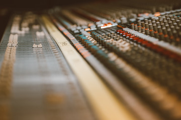 Professional audio mixing console with faders and adjusting knobs