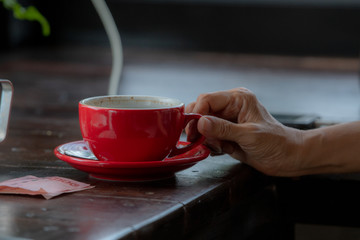 Red coffee cup and hand