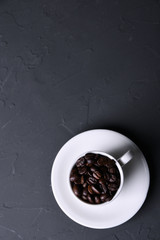 Obraz na płótnie Canvas Coffee cup and beans on old grey kitchen beton , rock table. Top view with copyspace for your text
