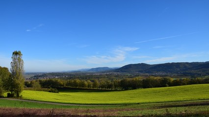 panoramic view across lush green meadows towards the rolling hills of the Black Forest, view from the Schutterlindenberg Lahr towards the village of Heiligenzell, Baden Germany