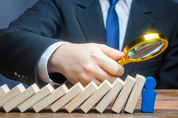 A businessman is studying stress resistance of a blue leader figure after a domino fall. Complete...