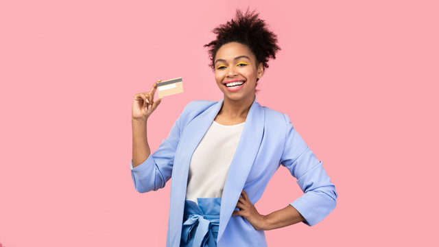 Afro girl holding credit card and looking at camera