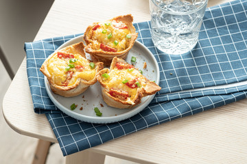 Baked egg, ham, tomato and toast cup for breakfast brunch.