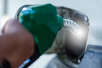 Man Handle pumping gasoline fuel nozzle to refuel. Vehicle fueling facility at petrol station....