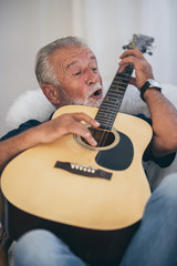 The old man and his guitar in the house