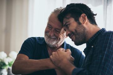 adult hipster son and old senior father stay for work at home, two generations have a beard talking together and relaxing with smile, happy enjoy living to isolation quarantine at home, Father's Day - obrazy, fototapety, plakaty