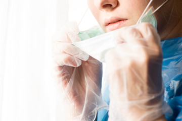 Young european woman protects herself from chinese coronavirus, wearing medical, sanitary mask and gloves