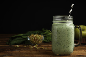 Tasty green buckwheat smoothie on wooden table