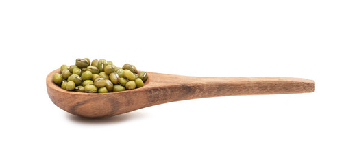 Brown wooden spoon with mung beans seen from the side and isolated on white background