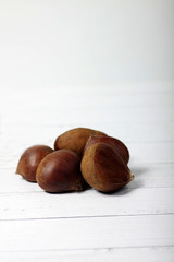 pile of raw sweet chestnuts isolated on white background