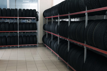 Car tires on rack in auto store © New Africa