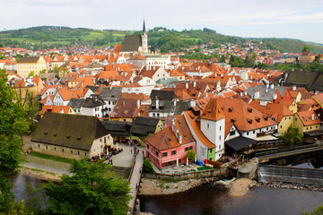Fototapeta na wymiar Aerial panoramic view of the typical colorful houses of Cesky Krumlov with Vltava river at the foreground and St. Vitus Church at the background (Czech Republic)