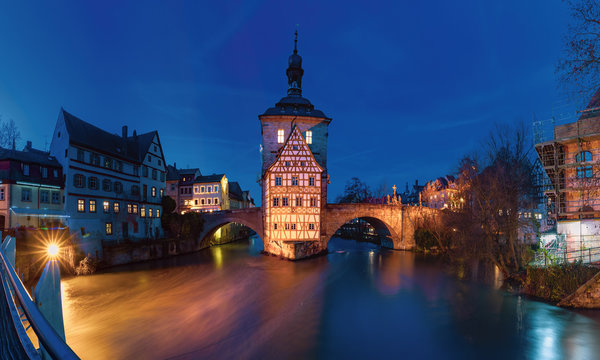 Panoramic view of Old town hall or Altes Rathaus with two bridges over the Regnitz river at night in Bamberg, Bavaria, Upper Franconia, Germany