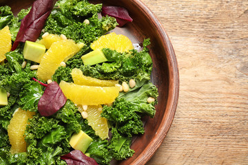 Obraz na płótnie Canvas Tasty fresh kale salad on wooden table, closeup