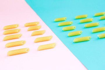 natural long tubular pasta on a pink and blue background