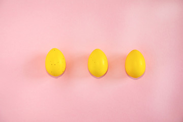 Fototapeta na wymiar Yellow easter eggs on pink background