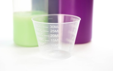 A small transparent measuring Cup. Close up. Isolated on a white background