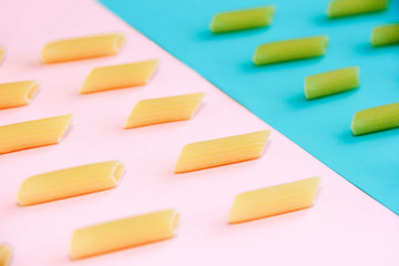 natural long tubular pasta on a pink and blue background