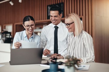 Smiling young businesspeople working at a table in an office