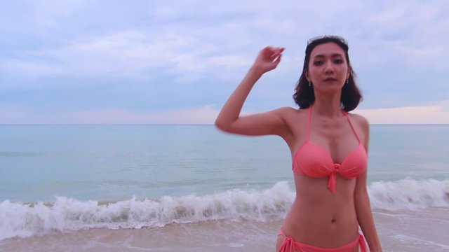 Asian lady pink bikini to relaxing on the beach, Summer holiday on the beach