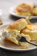 Breakfast. Cheesecakes with sour cream and jam on a light background. Background image, copy space