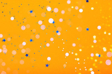 Orange festive background with blue stars and sparkles. The concept of the celebration, the day of St. Valentine, New Year, birthdays, ceremonies, events, etc.