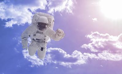creative concept of happy astronaut fly high in the sky with clouds, relax chill and dream idea...
