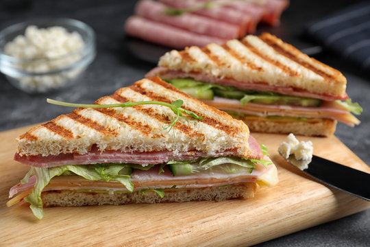 Tasty sandwich with ham on wooden board, closeup