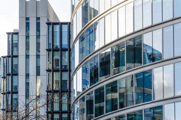 Close up view of detail on a modern glass building with reflective glass and contemporary design.