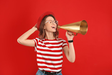 Naklejka premium Young woman with megaphone on red background