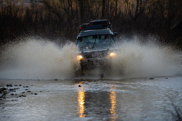 Off road car on mountain road. Wheel make splash of soil and dusty air competitor adventure in...