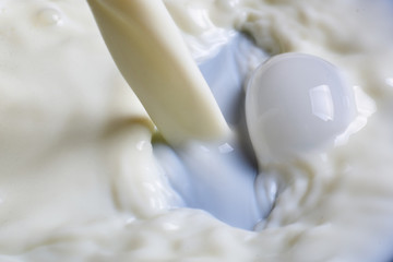 Pouring milk or white liquid.