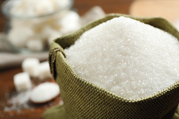 Fototapeta na wymiar Granulated sugar in sack on table, closeup