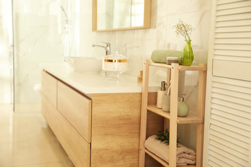 Shelving unit with toiletries in stylish bathroom interior