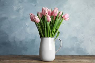 Beautiful pink spring tulips in vase on wooden table