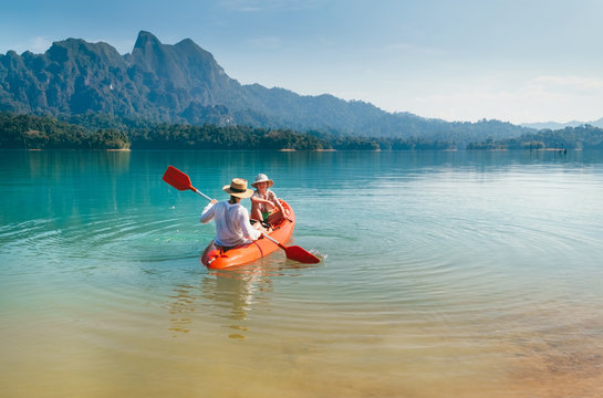 Mother and son floating on kayak together on Cheow Lan lake in Thailand. Traveling with kids concept image.