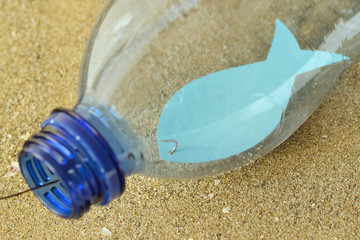 Close-up of fish on a hook in a plastic bottle - Concept of ecology and stop plastic pollution