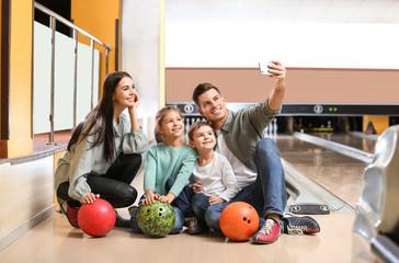 Fototapeta premium Happy family taking selfie in bowling club