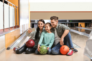 Fototapeta premium Happy family taking selfie in bowling club