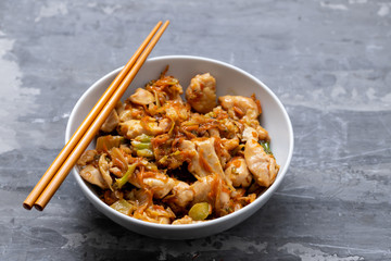chicken with vegetables in white bowl on ceramic background