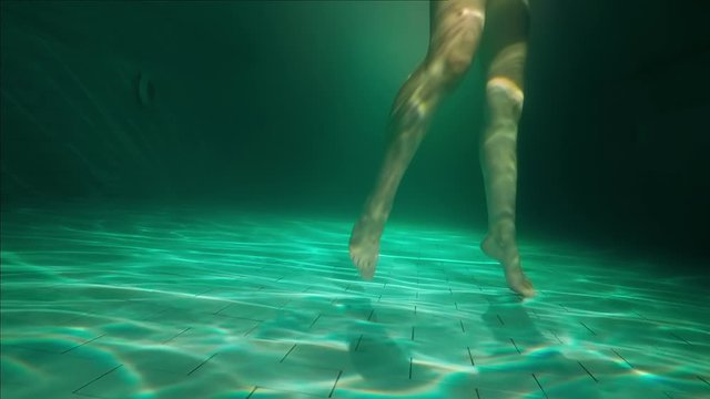 Girl dancing in the pool, underwater view