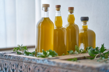 close up of four bottles filled with a yellow golden liquid that looks like olive oil or a juice...